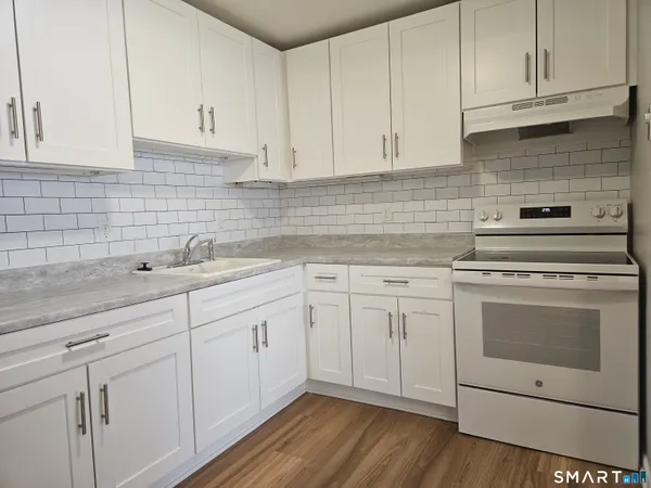 a kitchen with white cabinets stainless steel appliances and sink