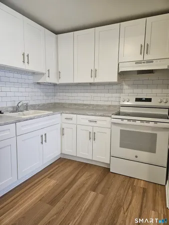a kitchen with white cabinets stainless steel appliances and sink