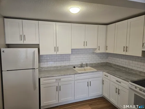 a kitchen with appliances a sink and cabinets