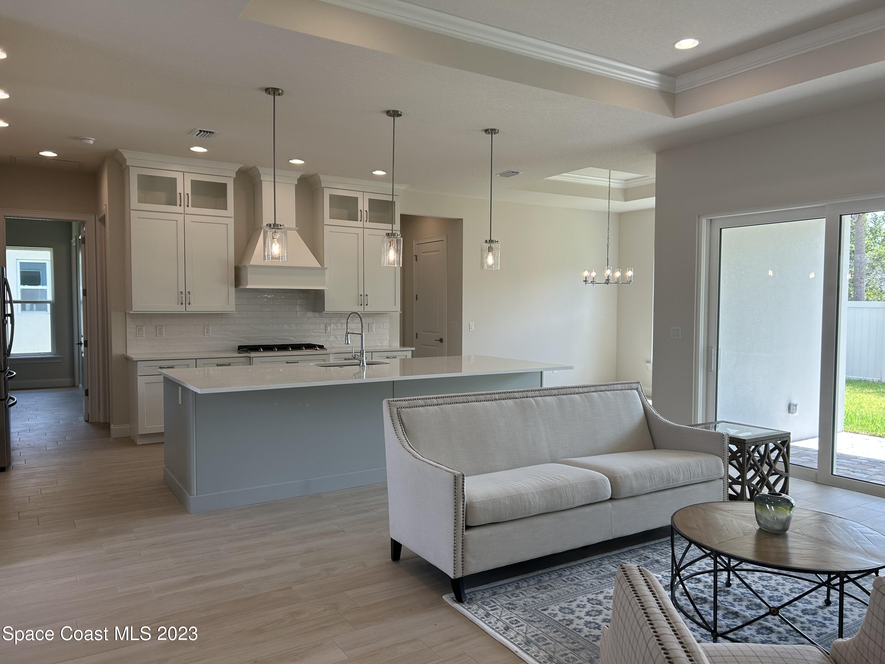 4095 Negal Circle Melbourne, FL 32901 - Photo 3 of 20 a living room with kitchen island furniture and a view of kitchen