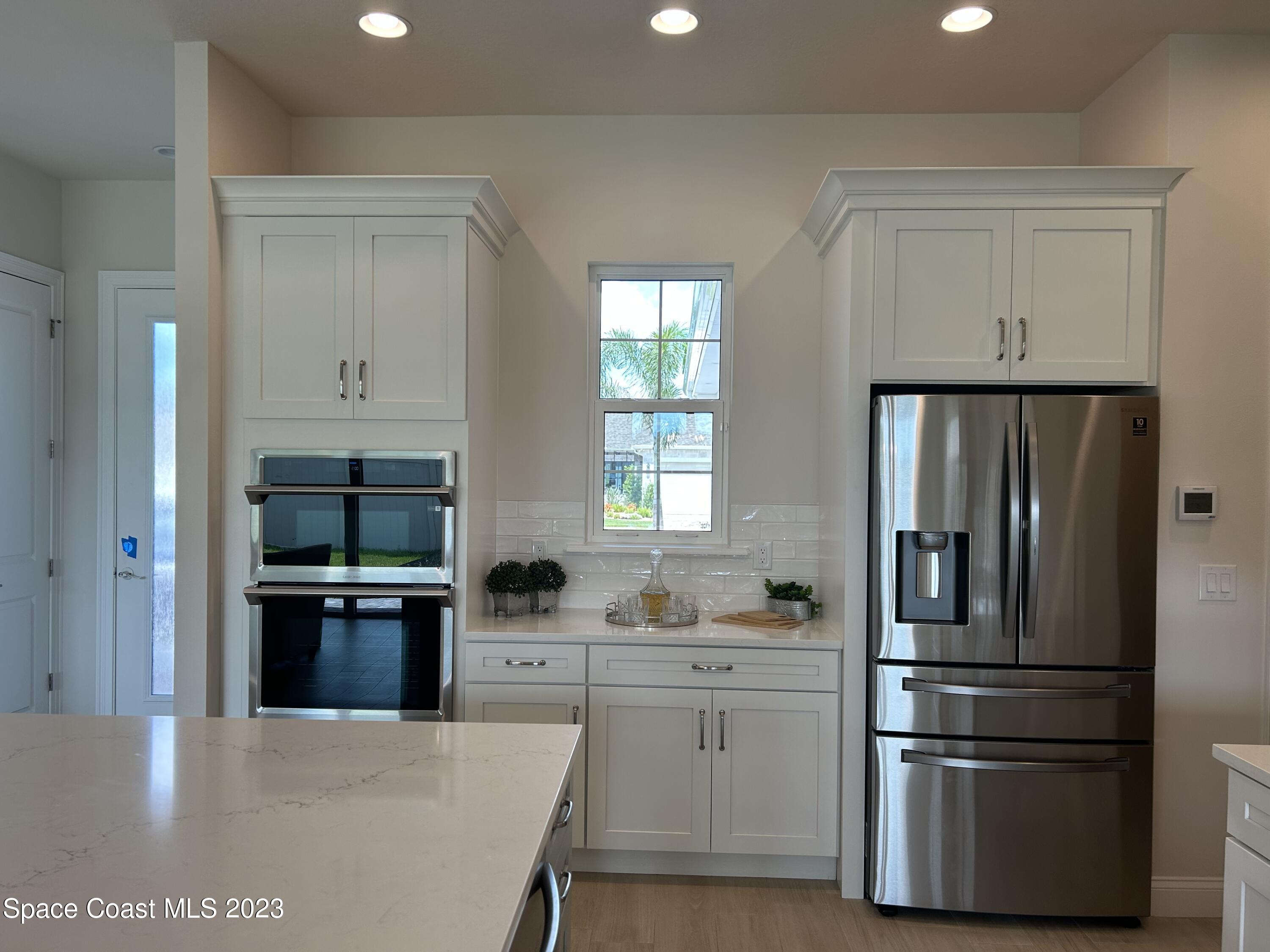 4095 Negal Circle Melbourne, FL 32901 - Photo 5 of 20 a kitchen with granite countertop a refrigerator and a stove top oven