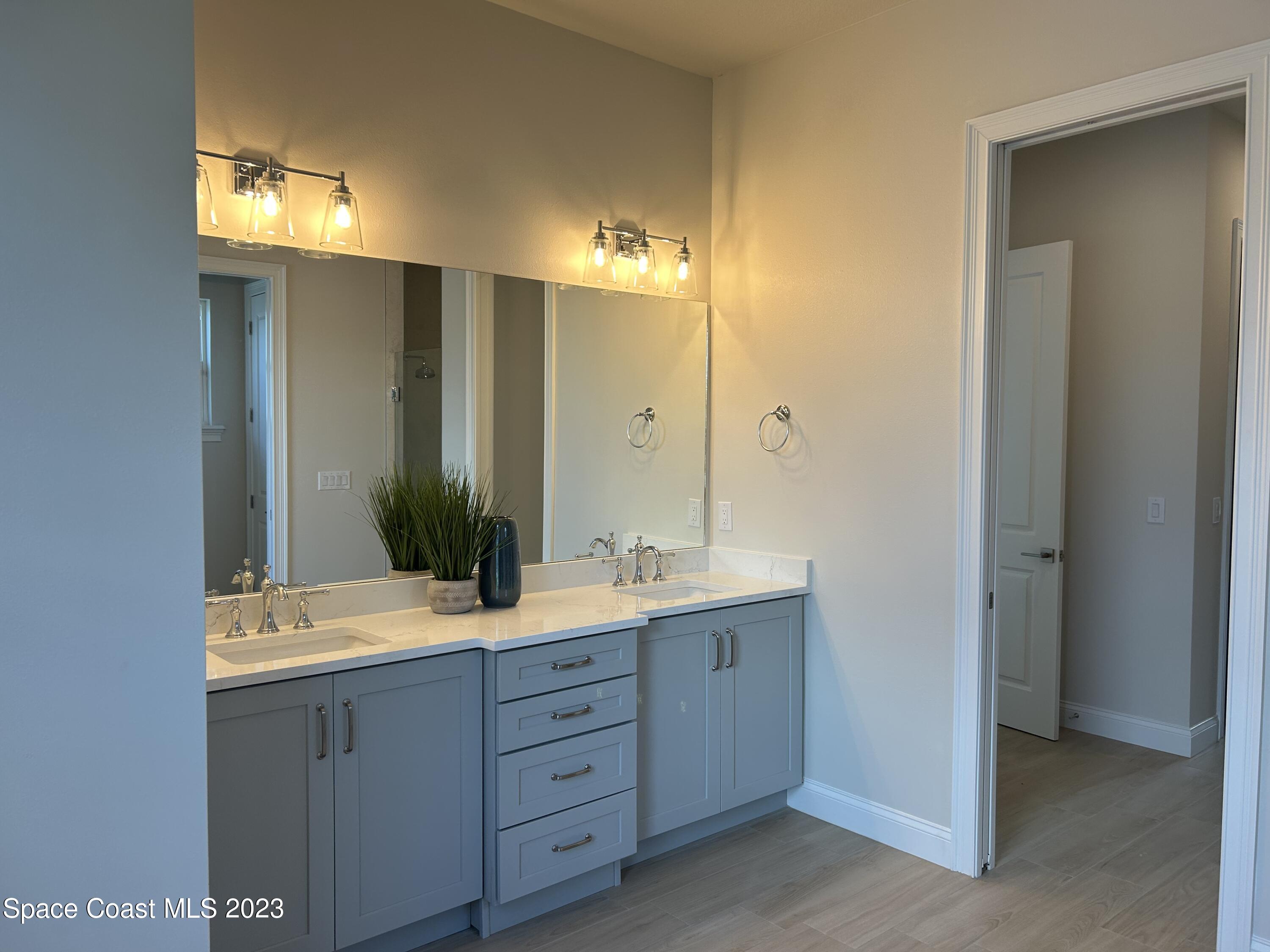 4095 Negal Circle Melbourne, FL 32901 - Photo 7 of 20 a bathroom with a double vanity sink and mirror