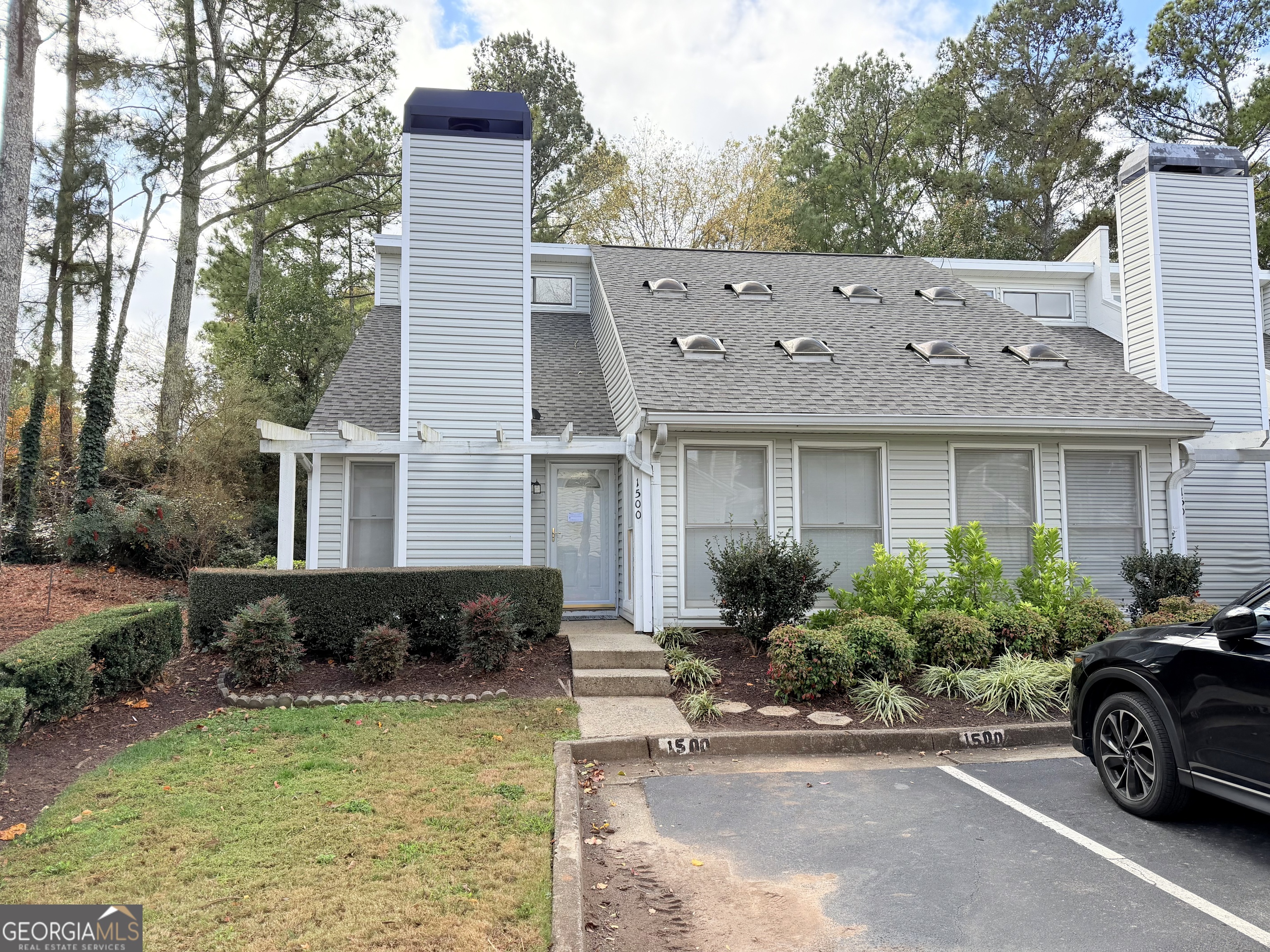 a front view of a house with a yard and potted plants