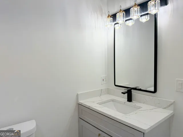 a bathroom with a sink toilet and mirror
