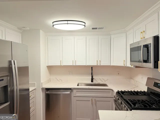 a kitchen with stainless steel appliances granite countertop a sink stove and refrigerator