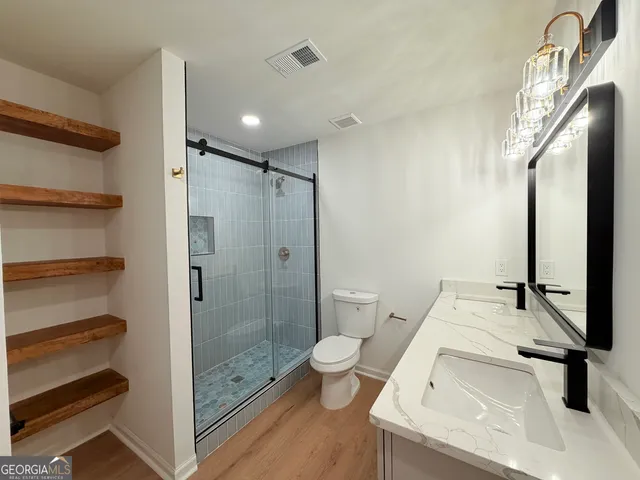 a bathroom with a sink a toilet and a large mirror