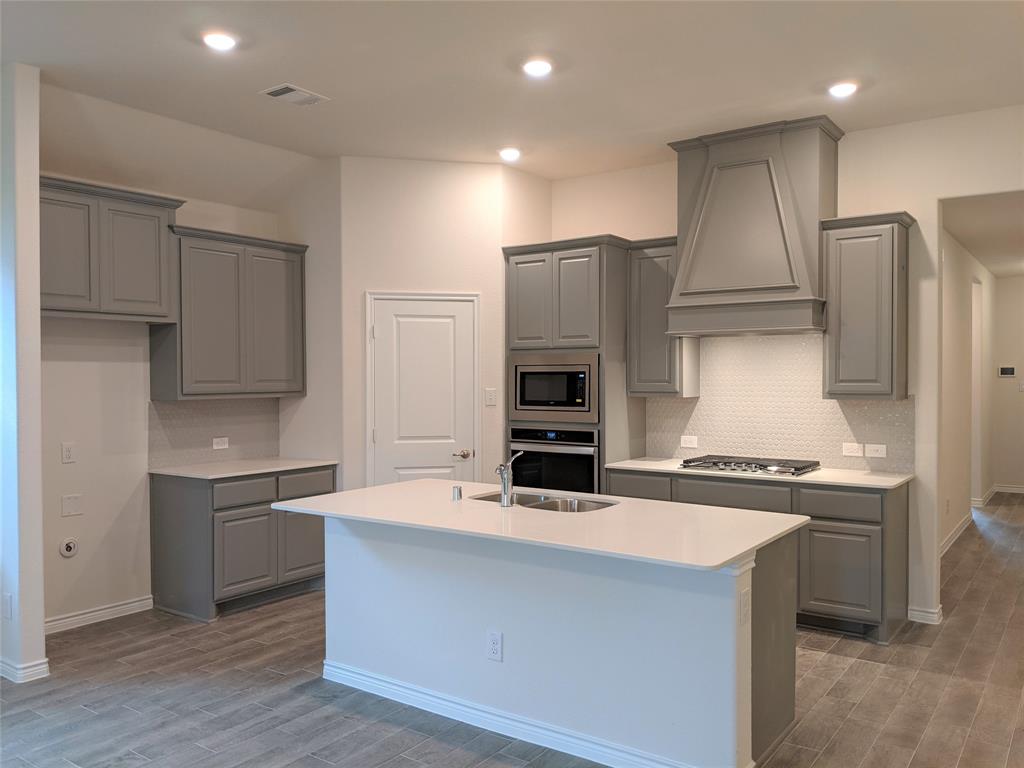 3024 Meredith Lane Forney, TX 75126 - Photo 13 of 22 a kitchen with kitchen island a counter top space stainless steel appliances and cabinets