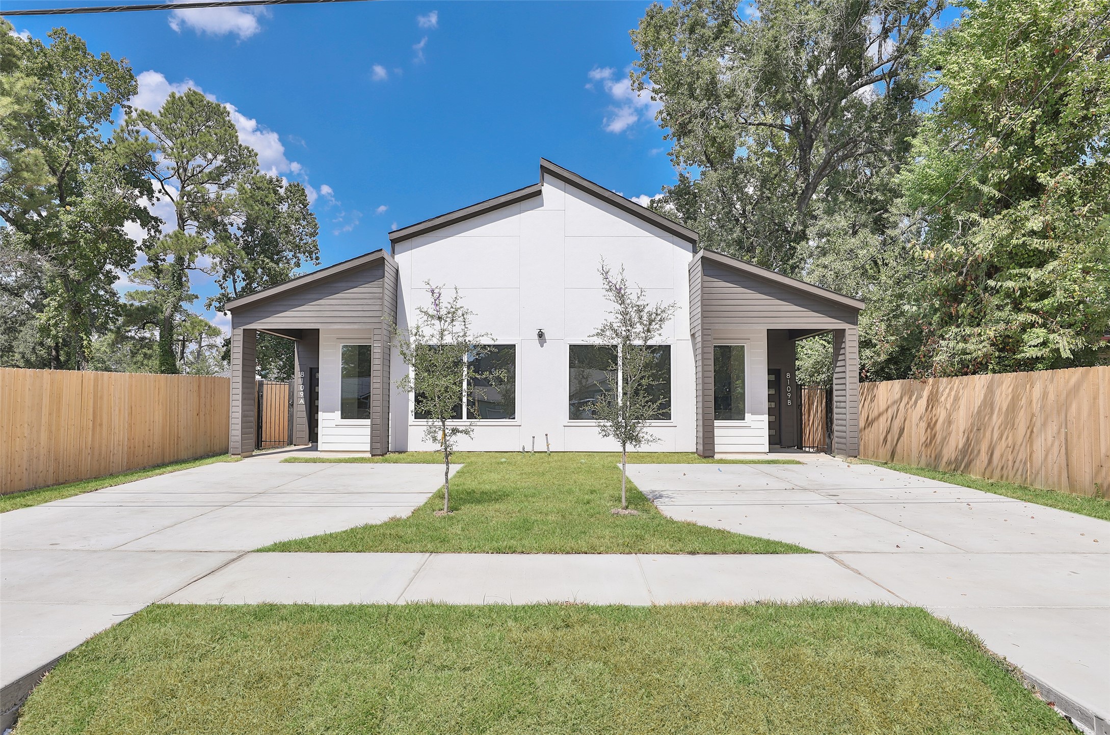 a view of a house with a yard and large tree