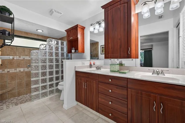 a bathroom with a double vanity sink mirror and shower