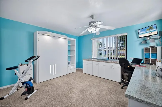 a view of a workspace with furniture and a window