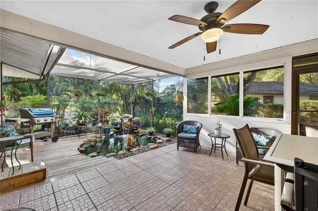 a living room with patio furniture and a large window