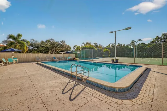 a view of a swimming pool with a patio and a yard