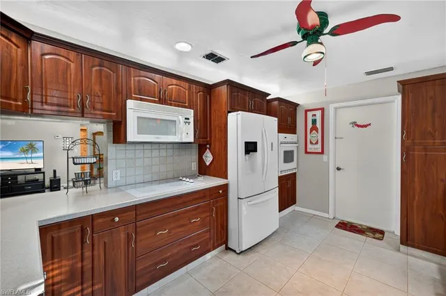 a kitchen with stainless steel appliances granite countertop a refrigerator a microwave oven with a sink and dishwasher