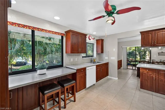 a large kitchen with kitchen island a large window in it