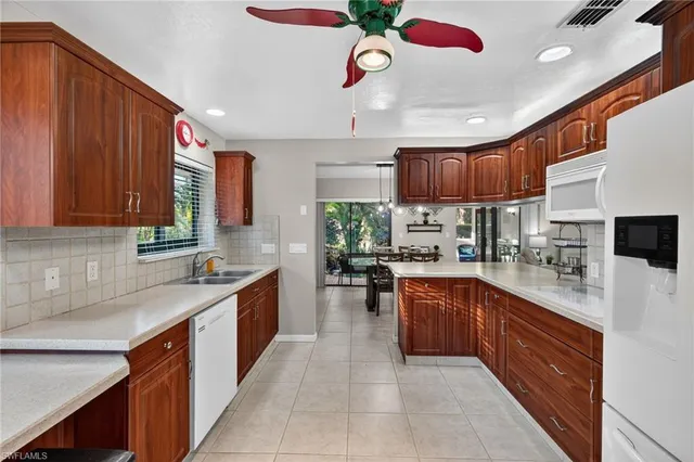 a kitchen with stainless steel appliances kitchen island granite countertop a sink stove cabinets and a refrigerator