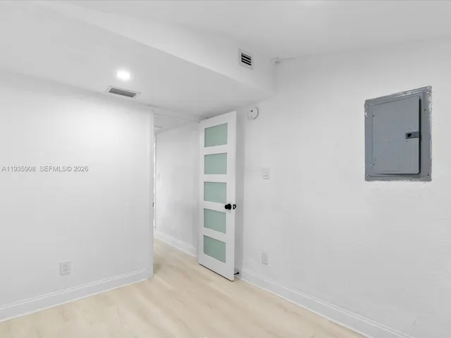 a view of an empty room with closet and a window