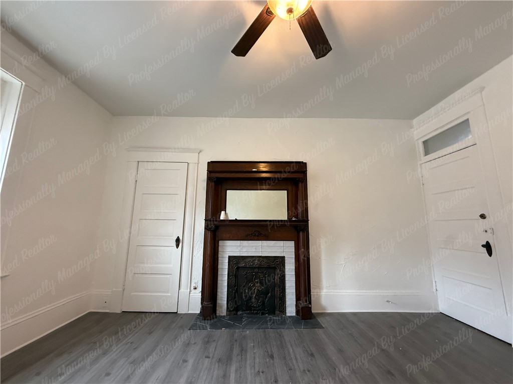44 West High Street, Unit B Springfield, OH 45502 - Photo 10 of 31 This inviting room features a traditional fireplace and stylish flooring, creating a cozy and comfortable living space.