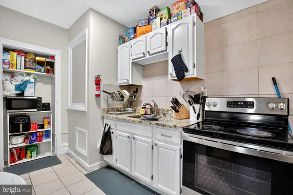 a kitchen with stainless steel appliances a stove and a bookshelf