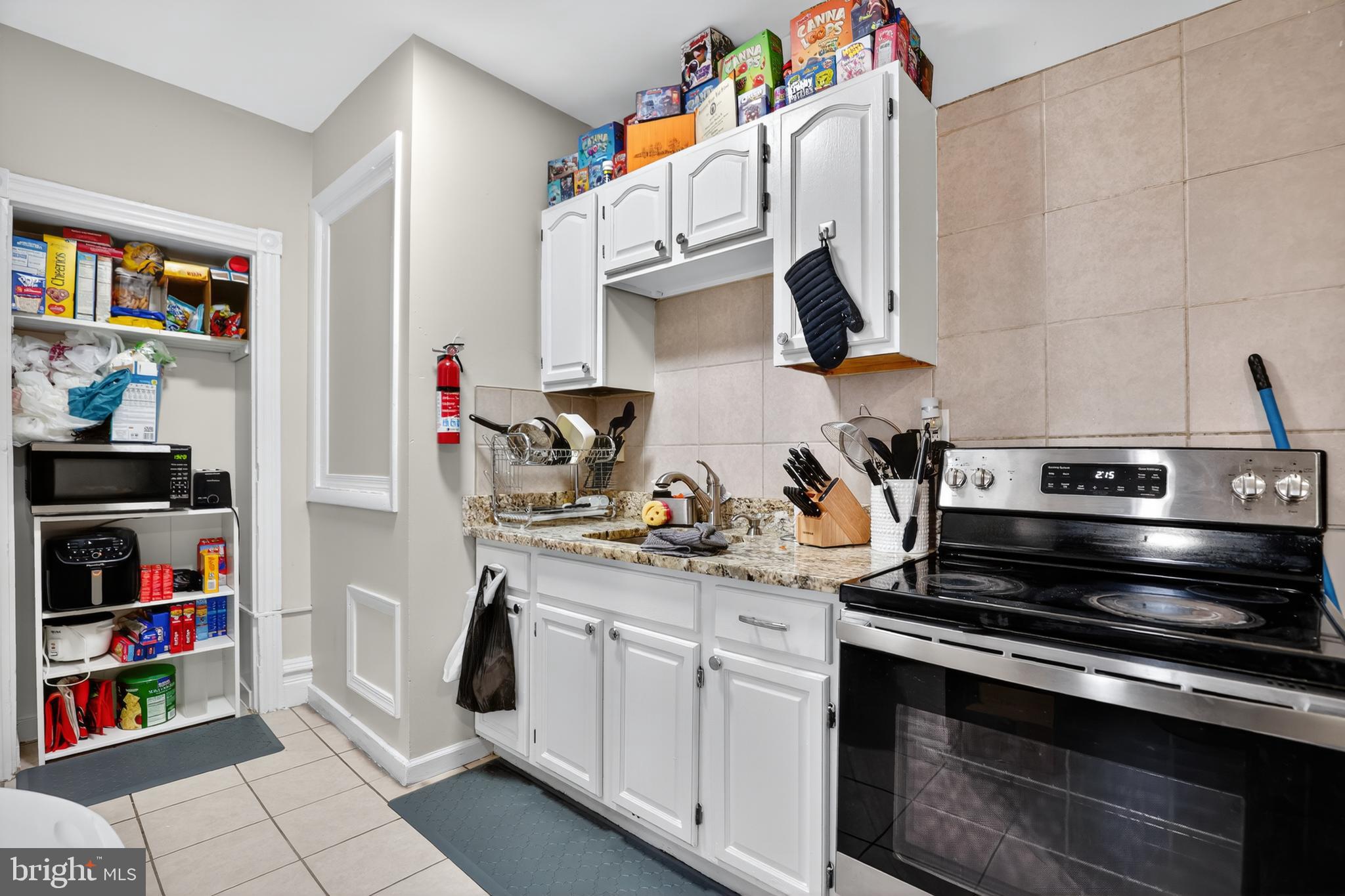 1259 North 10th Street Reading, PA 19604 - Photo 12 of 36 a kitchen with stainless steel appliances a stove and a bookshelf