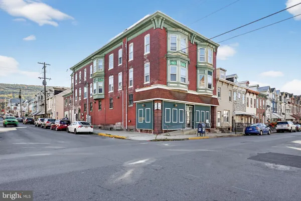 a city street lined with parked cars and buildings