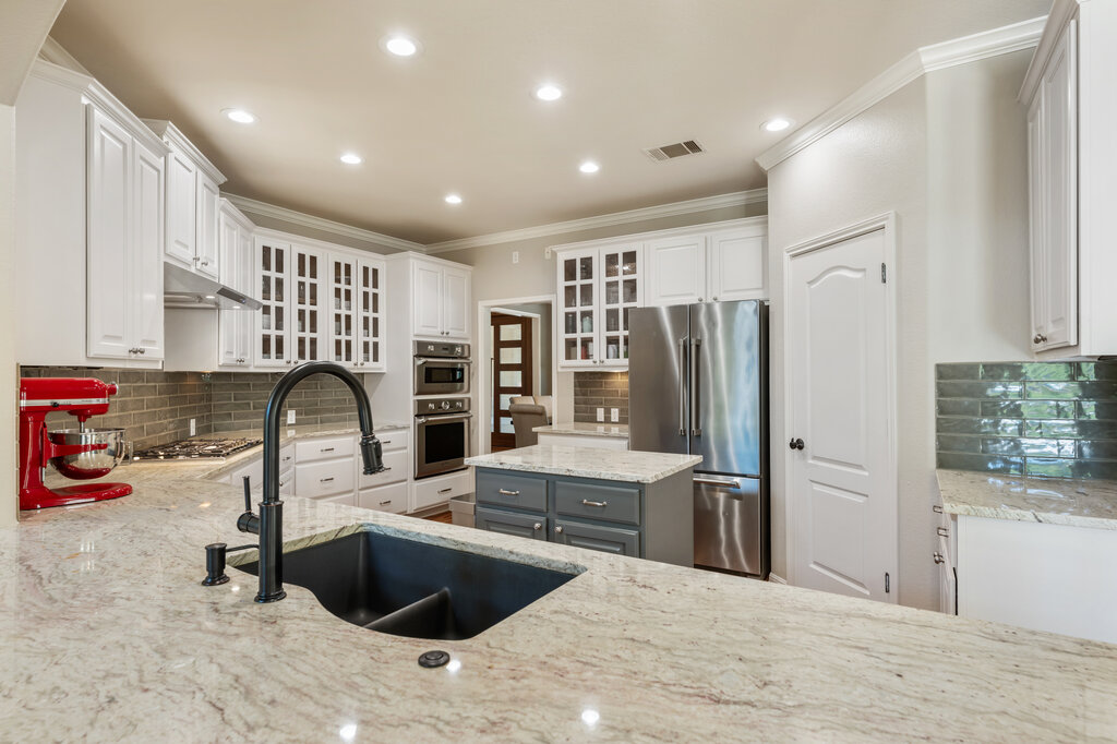 12801 Little Dipper Path Austin, TX 78732 - Photo 15 of 29 a kitchen with stainless steel appliances kitchen island granite countertop a refrigerator and a sink