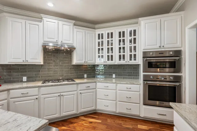 a kitchen with stainless steel appliances granite countertop a stove a sink and a microwave