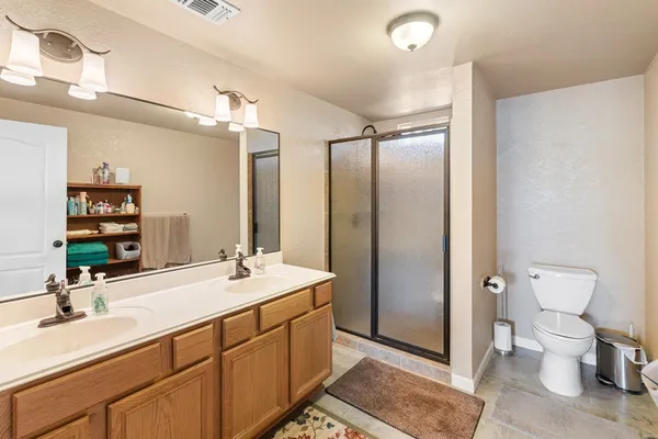 a bathroom with a double vanity sink toilet and mirror