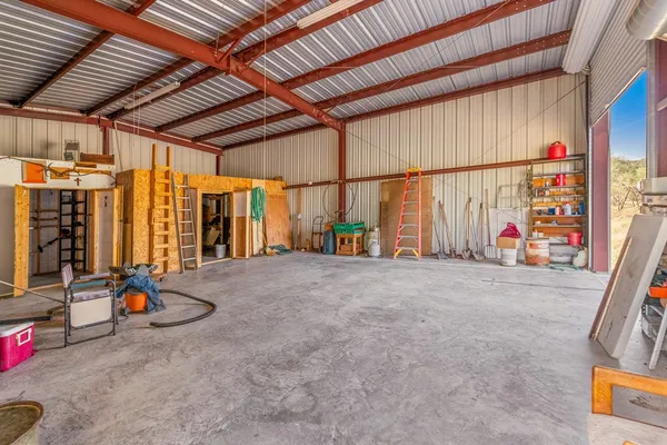 a view of a wooden chairs and table in the patio next to a yard