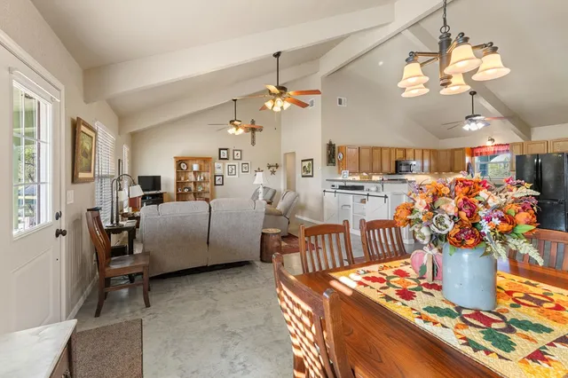 a living room with furniture kitchen view and a chandelier