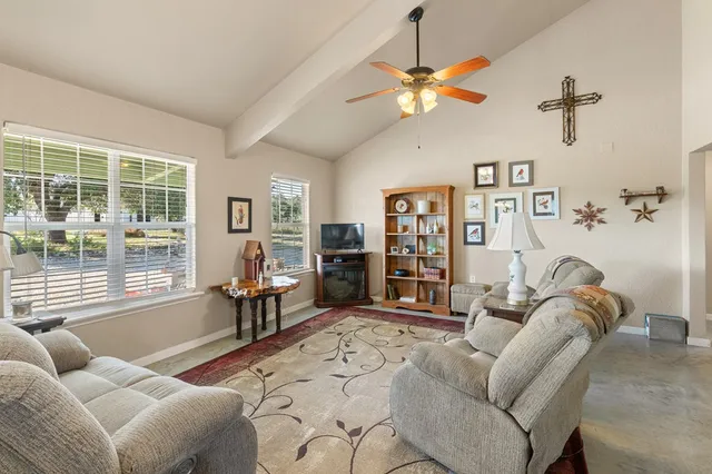 a living room with furniture a chandelier and a window