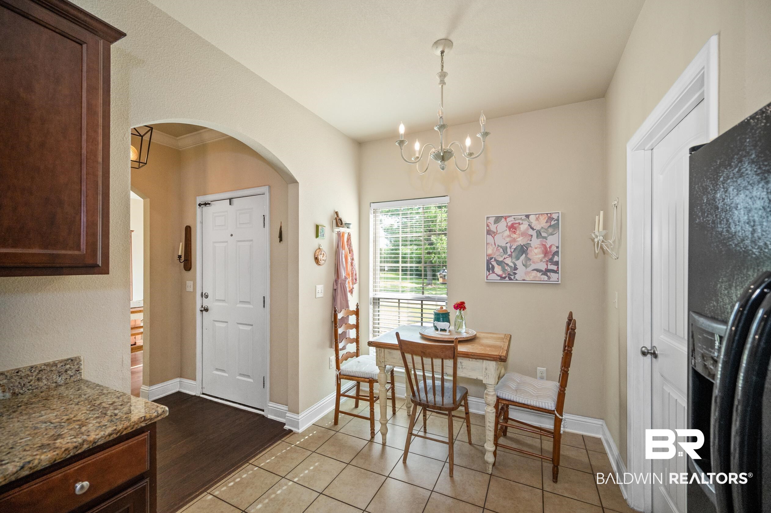 745 Bonaventure Street Fairhope, AL 36532 - Photo 10 of 36 Tiled dining area featuring crown molding and a notable chandelier