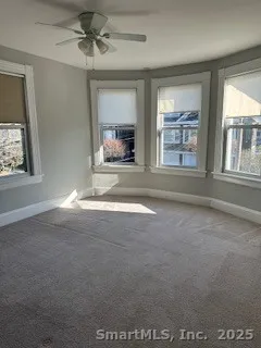 en empty room with windows and ceiling fan