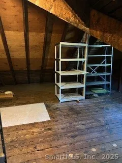 a view of an empty room with wooden floor and windows