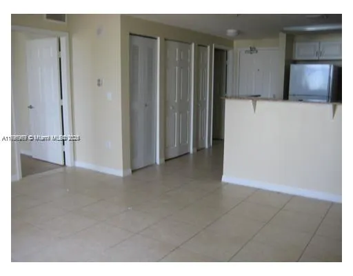 a view of an empty room with closet and utility room