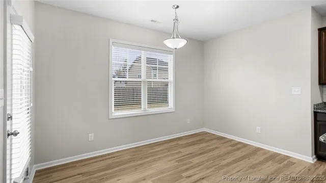 a view of empty room with wooden floor and windows