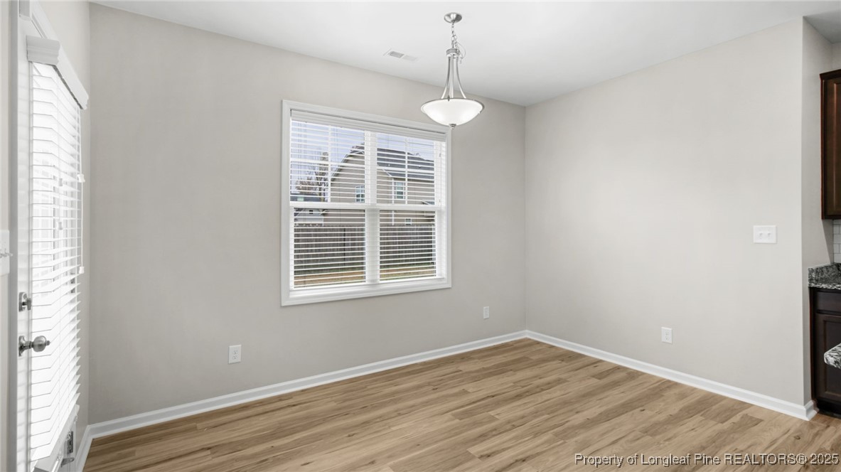 160 Chatfield Dr. Raeford, NC 28376 - Photo 11 of 32 a view of empty room with wooden floor and windows