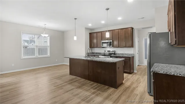 a kitchen with stainless steel appliances granite countertop a stove a sink and a refrigerator