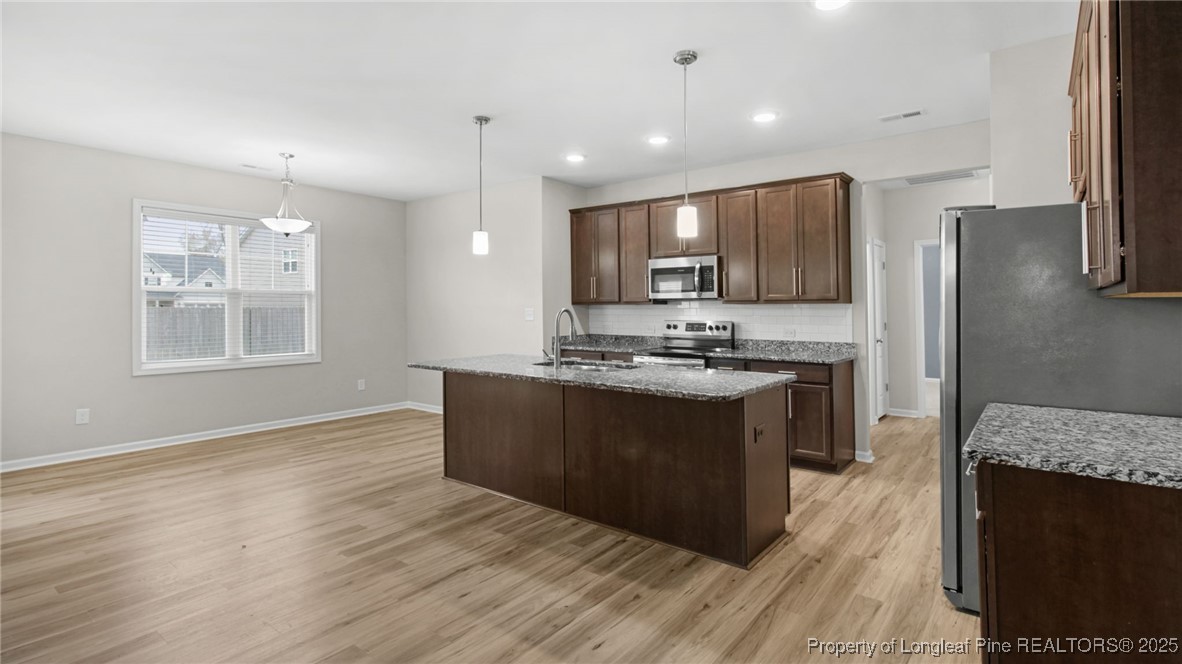 160 Chatfield Dr. Raeford, NC 28376 - Photo 12 of 32 a kitchen with stainless steel appliances granite countertop a stove a sink and a refrigerator