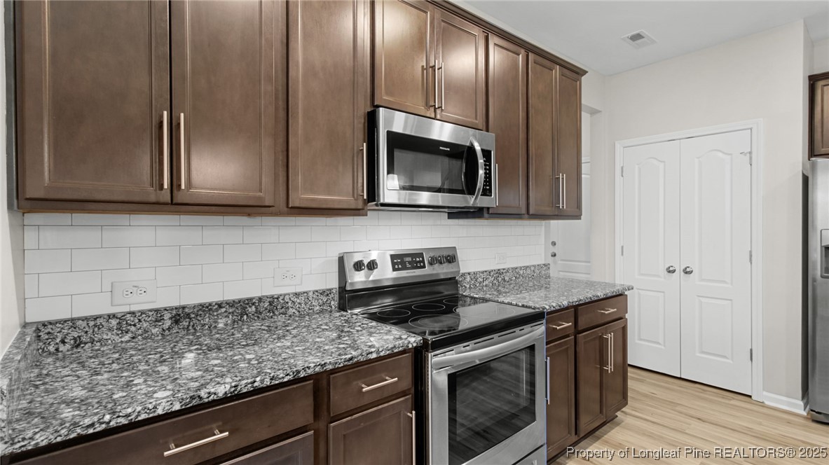 160 Chatfield Dr. Raeford, NC 28376 - Photo 16 of 32 a kitchen with stainless steel appliances granite countertop a sink stove and microwave