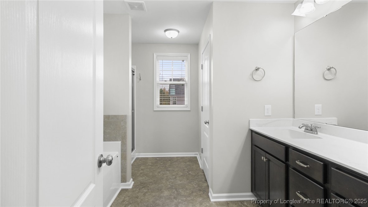 160 Chatfield Dr. Raeford, NC 28376 - Photo 28 of 32 a bathroom with a sink a mirror and a shower