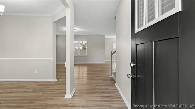 a view of a hallway with wooden floor and staircase