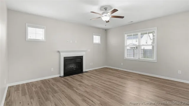 a view of an empty room with a window and fireplace