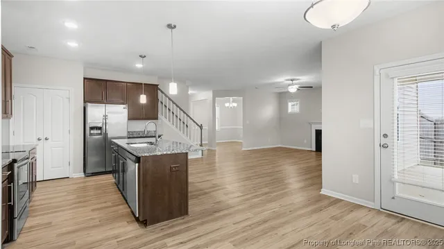 an open kitchen with a sink and breakfast area