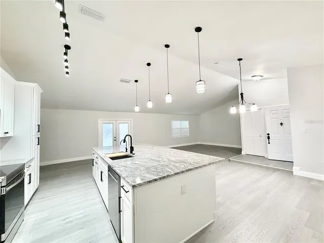 a kitchen with granite countertop sink and refrigerator