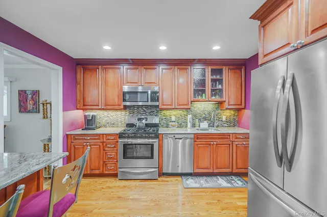 a kitchen with stainless steel appliances granite countertop a refrigerator and a stove