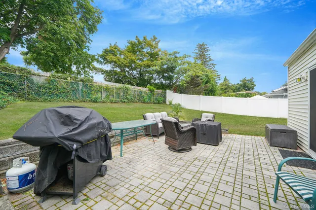 a view of a patio with table and chairs potted plants with wooden fence