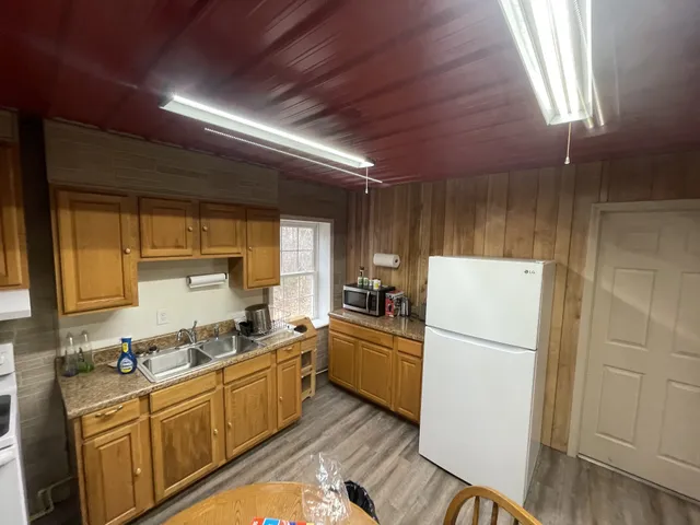 a kitchen with stainless steel appliances a stove a refrigerator and a dining table