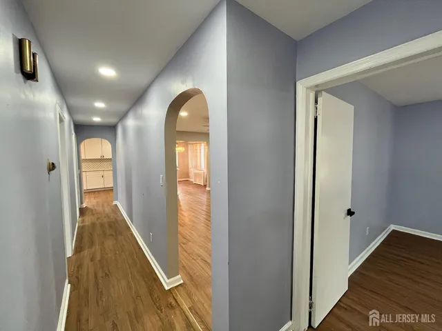 a view of a hallway with wooden floor and staircase
