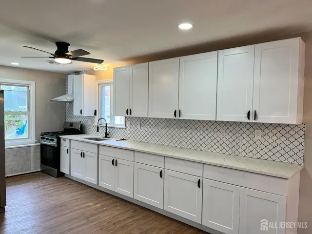 a kitchen with granite countertop white cabinets and white appliances