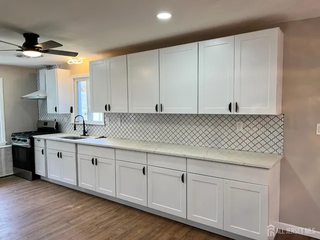 a kitchen with granite countertop white cabinets and sink